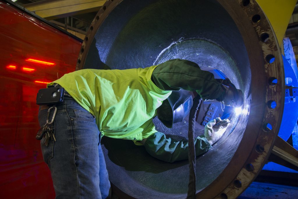 M. Davis welder working inside of a cone shaped vessel